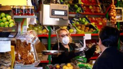 Una vendedora, protegida con mascarilla, trabaja en su puesto del mercado de abastos, en Córdoba.