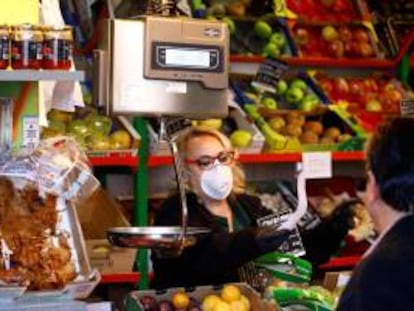 Una vendedora, protegida con mascarilla, trabaja en su puesto del mercado de abastos, en Córdoba.