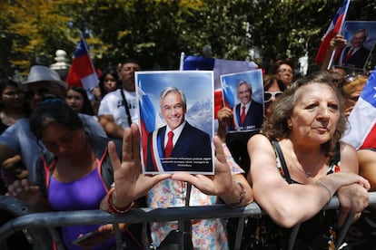 A woman holds a photograph of Sebastián Piñera as she waits for the arrival of his coffin in front of the Old Congress, in Santiago, on Wednesday, February 7.