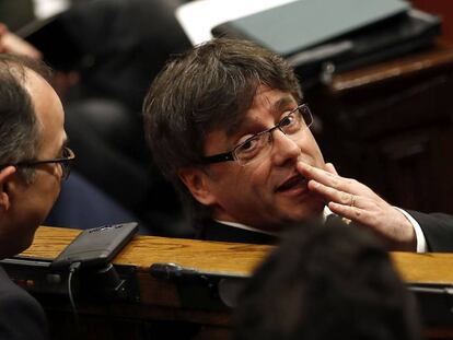 Puigdemont habla con Turull, en el Parlamento catalán.