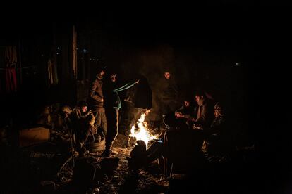 Un grupo de migrantes de origen argelino se calientan junto al fuego quemando troncos y alquitrán. En este campamento improvisado todos colaboran, se comparte comida, leña, ropa e información para organizar la travesía hacia Croacia.