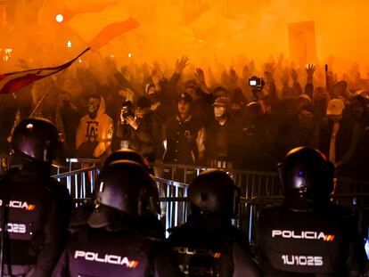 Un grupo de agentes, en fila frente a la valla y a los manifestantes concentrados en los alrededores de la sede del PSOE en la calle de Ferraz de Madrid, el martes.
