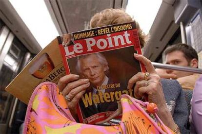 Una mujer lee un ejemplar de la revista <i>Le Point</i> <b>con un retrato de </b>Villepin y el texto "El espectro del Watergate".