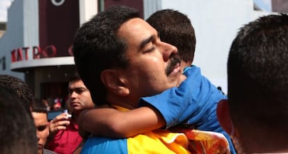 Maduro abraza a un ni&ntilde;o en un barrio de Caracas.