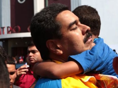 Maduro abraza a un ni&ntilde;o en un barrio de Caracas.