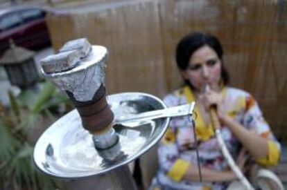 Una mujer fuma una pipa de agua el pasado 11 de julio en una cafetería del centro de Islamabad.