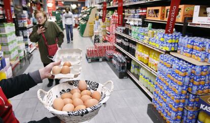 Huevos a granel y sección de bebidas incluyendo refrescos en un hipermercado.