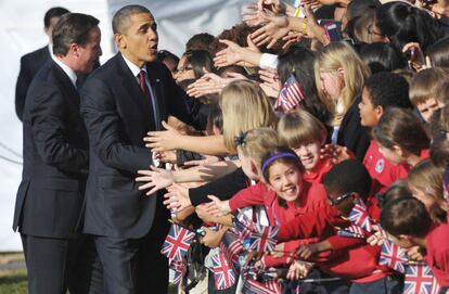 Obama y Cameron saludan al público congregado en los jardines de la Casa Blanca, entre ellos muchos escolares.
