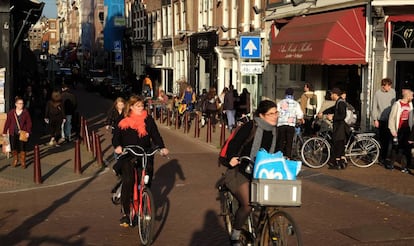 Mujeres pasean en bicicleta por &Aacute;msterdam.