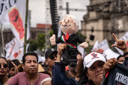 Una persona sostiene un muñeco con la imagen de López Obrador en el zócalo de Ciudad de México.