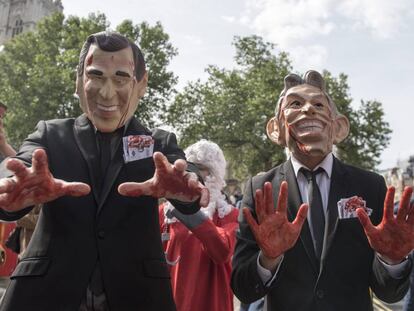 Manifestantes caracterizados como el ex primer ministro británico Tony Blair, y el expresidente estadounidense George W. Bush.