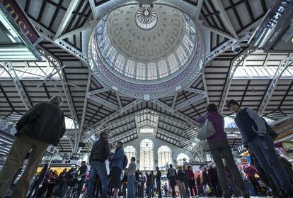 Vista interior de la cúpula central del mercado con gran cantidad de visitantes.