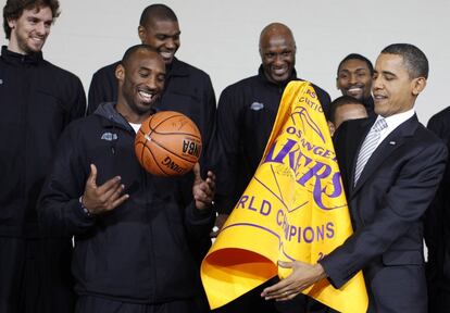 El presidente Barack Obama, con una bandera de Los Lakers que le entregó Kobe Bryant junto con otros miembros del equipo. Detrás del astro estadounidense se puede ver a Pau Gasol. Fue en diciembre de 2010.