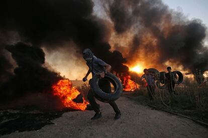 Un manifestante palestino carga neumáticos durante la protesta, el 12 de octubre de 2018, en Franja de Gaza. 