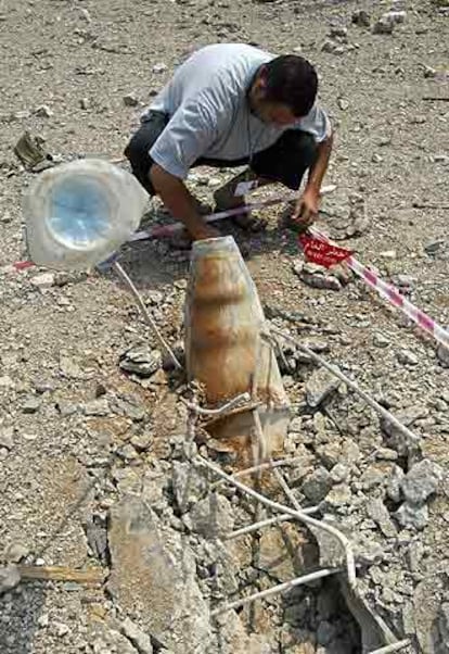 Un experto examina un proyectil israelí sin explotar al sur de Líbano.