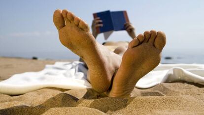 Una persona leyendo en la playa.