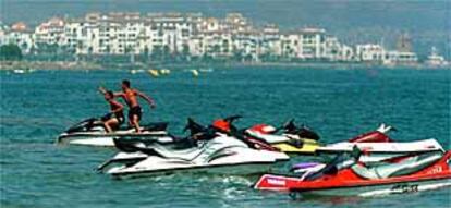 Dos jóvenes en una moto acuática alquilada en la playa de San Pedro de Alcántara, en Marbella.