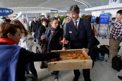 Un empleado del aeropuerto Charles de Gaulle de París reparte cruasanes entre los pasajeros cuyos vuelos se han visto cancelados por las cenizas del volcán en Islandia.