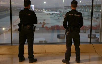 Two police officers patrol Madrid-Barajas airport after the Paris attacks.