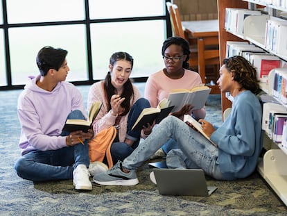 Four high school students studying together in library