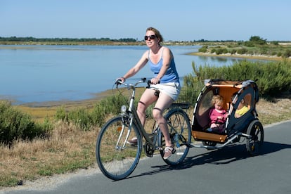 Una mujer en bici junto a sus hijos en la isla de Ré.