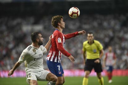 Carvajal y Griezmann siguen la trayectoria del balón.