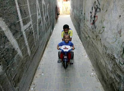 Dos niños palestinos juegan cerca de sus casas ayer en Gaza.