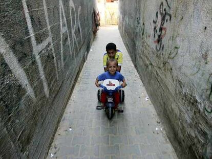 Dos niños palestinos juegan cerca de sus casas ayer en Gaza.