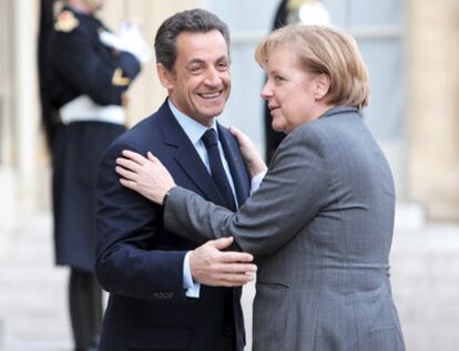 El presidente francés, Nicolas Sarkozy, da la bienvenida a la canciller alemana, Angela Merkel, a su llegada al Palacio del Elíseo en París hoy