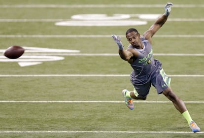 Justin Gilbert de los Oklahoma State pierde una captura durante un simulacro en el scouting de fútbol de la NFL en Indianápolis.