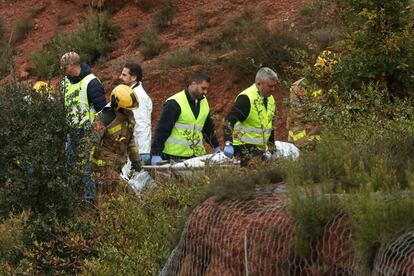Trabajadores del equipo de rescate trasladan el cuerpo de la persona fallecida en el siniestro.