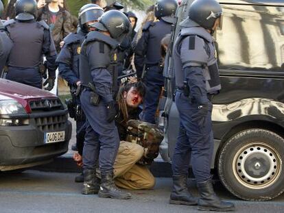 Un joven custodiado por policías durante los incidentes de febrero.