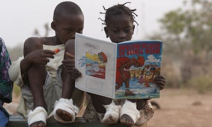 Fatawu Yakubu (izquierda) y Sadia Mesuna leen un c&oacute;mic sobre el gusano de Guinea en un centro de pacientes en Ghana, en 2007.
 