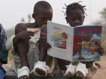 Fatawu Yakubu (izquierda) y Sadia Mesuna leen un c&oacute;mic sobre el gusano de Guinea en un centro de pacientes en Ghana, en 2007.
 