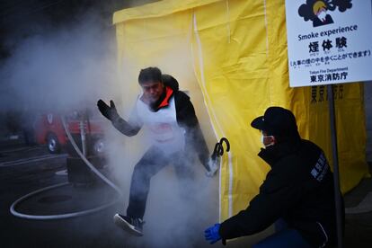 Los participantes asisten a una "experiencia de fumar" para ver cómo es caminar a través del humo durante un "simulacro de preparación para desastres" organizado por el gobierno metropolitano de Tokio en el Musashino Forest Sports Plaza, en la capital japonesa el 28 de enero.