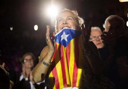 Una partidaria de la independencia de Cataluña viste una bandera independentista durante el acto a favor del referéndum del 1-O.