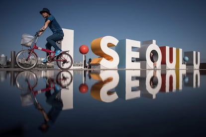 Personas posan con el logo de 'I Seoul U', el eslogán oficial de Seúl (Corea del Sur) para atraer turistas internacionales, en el parque Yeouido.