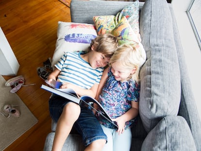 Dos niños leen y se divierten en su casa.