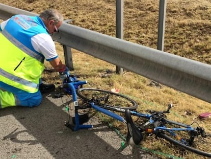 Un médico, junto a la bicicleta del fallecido, en el lugar del accidente.