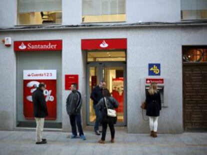 Varias personas frente a una oficina del Santander en Ronda.