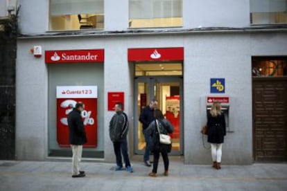 Varias personas frente a una oficina del Santander en Ronda.