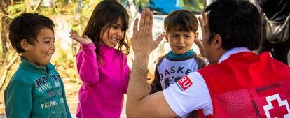 Un voluntario de la Cruz Roja juega con unos niños.