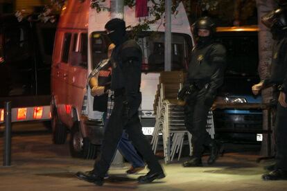 Agents dels Mossos custodien un detingut durant l'operació.