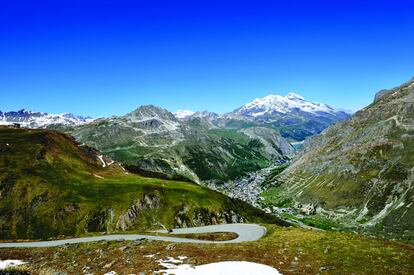 La carretera del puerto de montaña más alto del arco alpino no responde a una utilidad práctica, pues no cruza la frontera ni atraviesa la cadena principal de los Alpes. En la imagen, panorámica desde la vertiente norte, con la estación invernal de Val d'Isere en el fondo del valle.