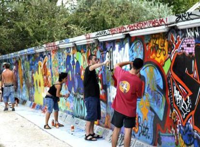 Asistentes al Festival de la Isla de Budapest pintando una reproducción del Muro de Berlín