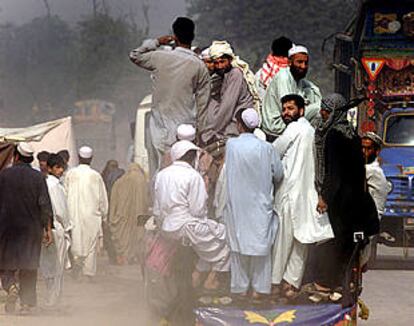 Refugiados afganos y ciudadanos locales se dirigen hacia un campo de refugiados en Phandu Village, cerca de Peshawar (Pakistán).