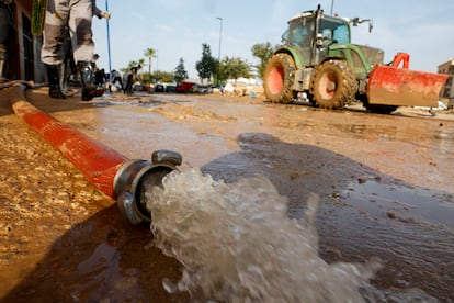 Una manguera drena agua de uno de los aparcamientos de las viviendas de Catarroja (Valencia), este martes.