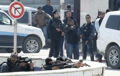 Polic&iacute;as tunecinos permanecen atrincherados tras un muro en el exterior del Parlamento.