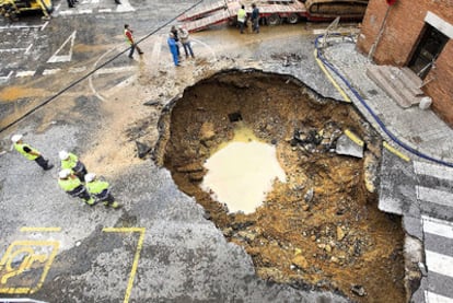 Los técnicos limpiaron ayer el socavón del barrio de La Teixonera de Barcelona de agua y tierra antes de taponarlo con hormigón.