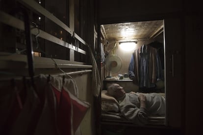 Tse Chu, un camarero jubilado, duerme en su cubículo.